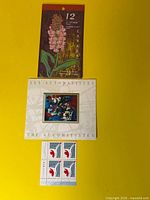 Front view of all three stamp items: Orchids booklet closed, Automatistes sheet, Millennium block