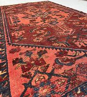 Oblique close-up of rug corner showing field, border and pile wear