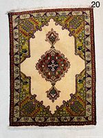 Full view of small Tabriz rug showing overall design and fringes