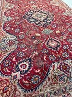 Angled close-up of rug center highlighting blue medallion and wear