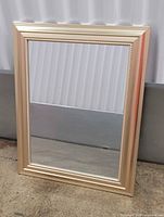 Front view of rectangular mirror showing gold-tone frame and beaded edge
