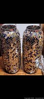 Both tall mirror mosaic vases standing side by side