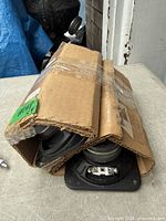 Bundle of four new 4x4 inch speakers wrapped in cardboard