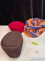 Three hats: red velvet, brown felt, striped fabric