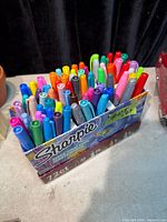 Front angled view of open Sharpie box showing assorted markers