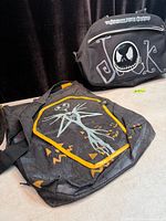 Two Nightmare Before Christmas messenger bags on floor