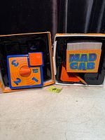 Game components inside box: plastic holder, card deck, accessory