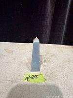 Front view of light blue angelite crystal point on tabletop
