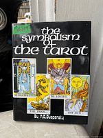 Front cover of The Symbolism of the Tarot book showing title, author, and Tarot card images