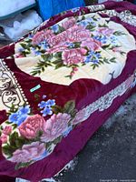 Full view of blanket showing floral pattern and burgundy border