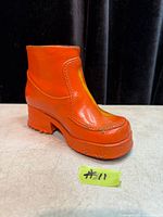 front and left side of orange metal boot coin bank