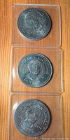 Front view of three 1991 Sir John A. Macdonald dollar coins in plastic flips