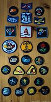 Full layout of 26 embroidered patches on wooden background