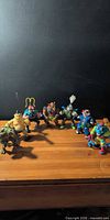 Group shot of all 8 action figures on wood surface