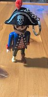 Front view of Playmobil pirate keychain figure showing hat, torso and legs