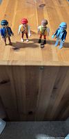 Group shot of four Playmobil pirate and ghost figures on wooden surface