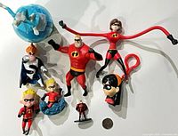 Group shot of all eight figures with coin for scale