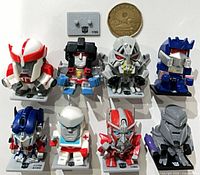 Group shot of all eight Transformers mini figures with coin for scale