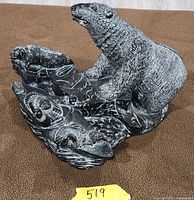 Full view of soapstone sculpture showing polar bear, Inuit in kayak, seal, fish