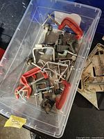 Top view of plastic box containing assorted C-clamps
