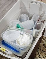 overview of mixed plastic food storage containers in white tote