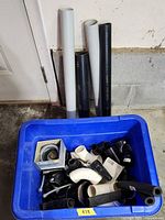 Overall lot with blue tote, assorted fittings, four long pipes leaning against wall