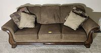 Front view of brown fabric sofa with two pillows