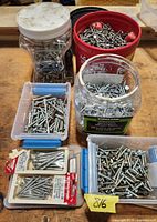 Multiple plastic containers filled with assorted screws