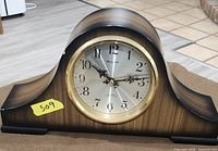 Front view of Bulova wood veneer mantel clock showing dial and bezel