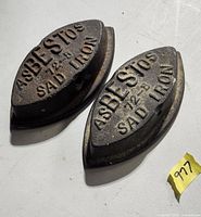 Two cast iron sad irons, lettering visible