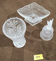 Vase, compote and bell arranged on surface showing patterns and shapes