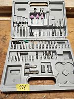 Open gray plastic case displaying all remaining bits and accessories, showing missing pieces