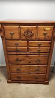 Front view of knotty pine dresser showing honey finish, brass pulls, carved star motif