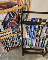 Two book racks filled with assorted Clive Cussler books
