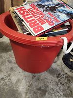 Top view of red bucket showing British Military Operations Overseas book on top of other books