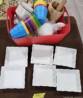 Overall lot showing square dishes and red bin with assorted kitchenware