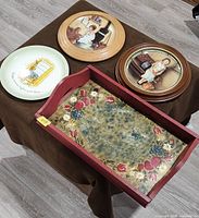 Top view of ceramic plate, two wooden plaques and red tray displayed together