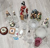Top-down view of entire lot showing barometer, figurines, glassware and decorative items