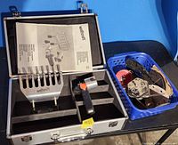 Open aluminum case with Wolfcraft holder, instruction sheet, handle; adjacent basket with various discs and pads