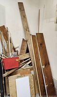 Pile of assorted lumber scraps and red plastic storage bin