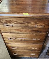 Front view showing all four drawers, wooden pulls, medium brown finish, scratches