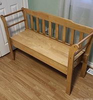 Overall view of solid wood storage bench with slatted back and side rails
