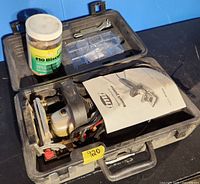 Open carrying case showing TMT biscuit jointer, manual, jar of #10 biscuits and accessory box