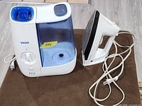 Front view of Vicks humidifier and clothes iron with cords