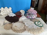 Group shot of all textiles including doilies, tea cosies, placemats