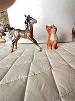 Front view of foal and cat figurines