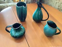 Four ceramic pieces on table showing overall forms and glaze