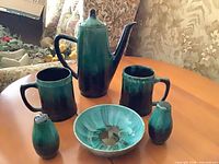 Full view of coffee pot, mugs, shakers, bowl