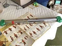 Bullworker apparatus resting on table beside unfolded exercise wall chart