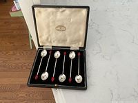Open case showing six teaspoons with red bean finials